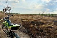 Seseorang menggunakan kendaraan trail meninjau beberapa hektare lahan yang hangus akibat kebakaran hutan dan lahan (karhutla) di Landasan Ulin Tengah, Kecamatan Liang Anggang, Banjarbaru, Kalimantan Selatan, Senin (28/7/2025). (ANTARA/Tumpal Andani A)