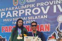 Teks foto : Riyanti dan pelatih panahan NPC Balangan Syahrudi Rahman foto: MC Balangan