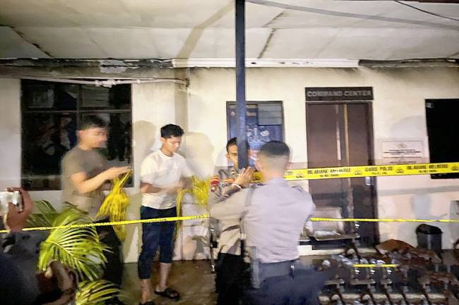 Petugas memasang garis polisi di lokasi setelah terjadinya kebakaran di Polres Banjarbaru pada Rabu malam. (ANTARA/Firman)
