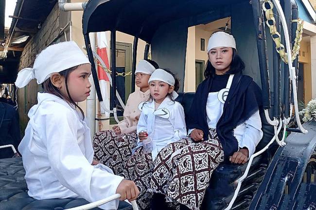 
Yulviana (kanan) dan sejumlah anak bajang lainnya mengikuti kirab sebelum menjalani ruwatan anak berambut gimbal acara puncak Dieng Culture Festival (DCF) XV Tahun 2025 di pelataran Kompleks Candi Arjuna, Desa Dieng Kulon, Kecamatan Batur, Kabupaten Banjarnegara, Minggu (24/8/2025). (ANTARA/Sumarwoto)
