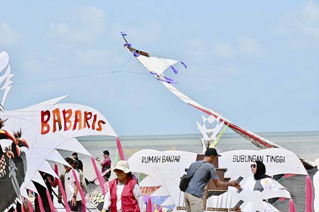 Para peserta menyiapkan layang-layang raksasa sebelum diterbangkan pada kegiatan Festival Layang-Layang Dandang 2025 di Pantai Batakan Baru, Kabupaten Tanah Laut, Kalimantan Selatan, Minggu (31/8/2025). (ANTARA/Tumpal A Aritonang)