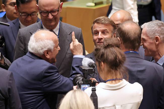 Duta Besar Palestina untuk PBB Riyad Mansour (kiri) menyambut Presiden Prancis Emmanuel Macron (tengah) saat tiba di Markas Besar PBB untuk menghadiri KTT PBB tentang Palestina di New York, Senin (22/9/2025). (Foto: AFP/Ludovic MARIN)