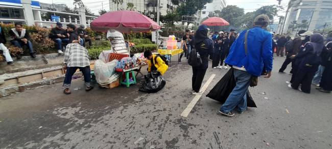 Aksi unik mahasiswa dan massa punguti sampah usai demo di DPRD Kalsel, Senin (1/9/2025) sore. (SuarIndonesia/YI)