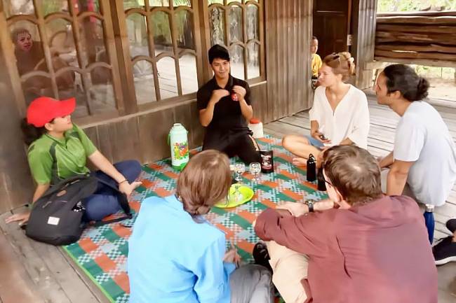 Raya Sadianor bercerita tentang kopi rempah kepada sejumlah wisatawan mancanegara yang berkunjung ke desanya. (ANTARA/Dokumentasi Pribadi)  