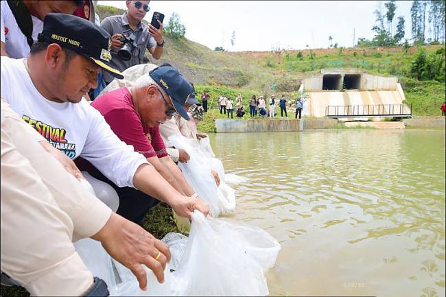 Program kegiatan tebar benih ikan yang dilakukan Otorita IKN di embung yang ada di KIPP IKN sebagai upaya penguatan ketahanan pangan protein hewani. (SI/DOK Humas OIKN)