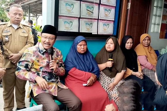 Menteri Sosial Saifullah Yusuf berbincang-bincang dengan keluarga penerima manfaat bansos, saat kunjungan kerja ke Puskesos Desa Margakaya, Kabupaten Karawang, Jabar, Selasa (21/10/2025). (ANTARA/Ali Khumaini)