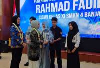 Bunda PAUD Kalsel menyerahkan bantuan siswa kurang mampu secara simbolis. Foto : MC Kalsel