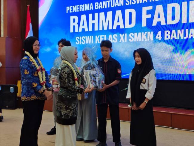 Bunda PAUD Kalsel menyerahkan bantuan siswa kurang mampu secara simbolis. Foto : MC Kalsel