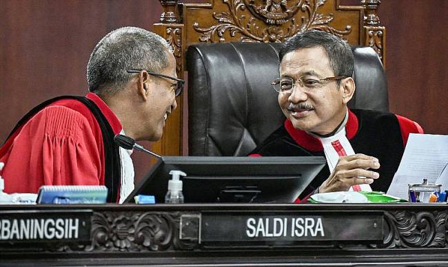 Ketua Mahkamah Konstitusi (MK) Suhartoyo (kanan) berbincang dengan Wakil Ketua MK Saldi Isra (kiri) saat memimpin sidang putusan di Gedung Mahkamah Konstitusi, Jakarta, Kamis (16/10/2025).(ANTARA FOTO/FAUZAN)
