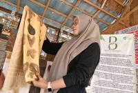 Ketua Bentala Belangian Idah Fitriati dengan produk kain sasirangan pewarna alami dari alam Geopark Pegunungan Maratus di desanya di Belangian, Kabupaten Banjar, Kalsel. (Foto: ANTARA)