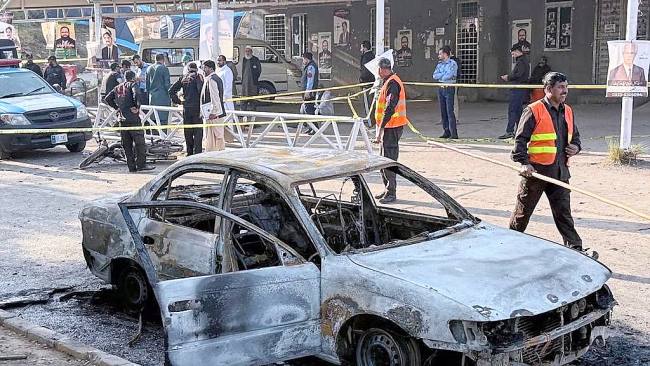 Petugas keamanan dan petugas penyelamat berkumpul di lokasi kejadian setelah bom bunuh diri di luar gerbang pengadilan distrik, di Islamabad, Pakistan. (Foto: theaustralian.com.au/AP/Mohammad Yousuf)
