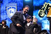 Penghargaan diserahkan Ketua IMI Kalsel Edy Sudarmadi kepada pembalap Motocross cilik asal Kandangan pada puncak gelaran Jambore IMI Kalsel, di Gedung Olahraga (GOR) Babussalam, Kota Banjarbaru, Sabtu (13/12/2025) malam. (SuarIndonesia/Ist)