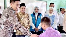 Wakil Menteri Dalam Negeri (Wamendagri) Akhmad Wiyagus (kiri) didampingi Wakil Gubernur Kalsel Hasnuryadi Sulaiman (kedua kiri) menyapa salah satu siswa saat meninjau penyaluran paket Makan Bergizi Gratis (MBG) di SMAN 1 Gambut, Kabupaten Banjar, Kalimantan Selatan, Rabu (3/12/2025). (Foto: ANTARA/Tumpal Andani A)