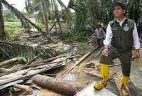 Menteri Kehutanan Raja Juli Antoni berdiri di atas tumpukan kayu yang hanyut saat meninjau proses pencarian korban banjir bandang di Pasak Kayu, Nagari Salareh Aia, Palembayan, Agam, Sumatera Barat, Minggu (30/11/2025). (Foto: Antara/Wahdi Septiawan)