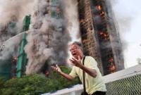 Warga Hong Kong histeris setelah mengetahui istrinya terjebak di salah satu kompleks apartemen Wang Fuk Court yang terbakar di Hong Kong. (Foto: Reuters/Tyrone Siu)