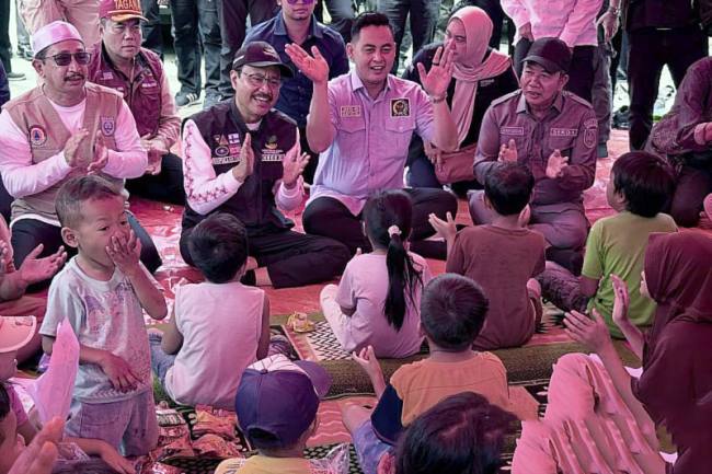 Menteri Sosial (Mensos) RI Saifullah Yusuf (rompi hitam) memberikan dukungan psikososial bagi anak-anak korban banjir yang mengungsi di Posko Puskesmas Sungai Tabuk, Kabupaten Banjar, Kalimantan Selatan, Minggu (4/1/2026). (ANTARA/Tumpal Andani A)