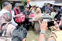 Menteri Sosial (Mensos) RI Saifullah Yusuf (kedua kiri) menyalurkan bantuan sembako kepada korban terdampak banjir di Sungai Tabuk, Kabupaten Banjar, Kalimantan Selatan, Minggu (4/1/2026). (ANTARA/Tumpal Andani A)