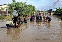 Prajurit Kodam 1204/Sanggau menolong masyarakat yang akan melintasi jalan yang terendam banjir. (Foto: Dok Pendam XII/Tpr)
