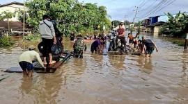 Prajurit Kodam 1204/Sanggau menolong masyarakat yang akan melintasi jalan yang terendam banjir. (Foto: Dok Pendam XII/Tpr)
