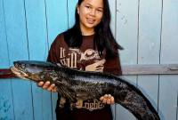 Semringah wajah anak Labo menggendong ikan gabus yang dibeli dari Pasar Inai, Malinau. (Foto: Dokumentasi Pribadi Labo)