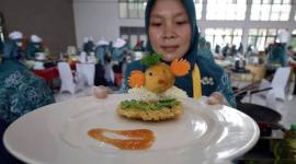 Seorang peserta memperlihatkan makanan berbahan baku ikan saat Lomba Cipta Menu Ikan di Kabupaten Kediri, Jawa Timur, Rabu (3/12/2025). Kegiatan yang diselenggarakan Pemkab Kediri tersebut sebagai upaya mendorong ibu rumah tangga menciptakan menu makanan sehat berbahan baku ikan dengan tampilan yang menarik agar anak gemar makan ikan guna mencegah stunting. (Antara Foto/Prasetia Fauzani)
