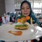 Seorang peserta memperlihatkan makanan berbahan baku ikan saat Lomba Cipta Menu Ikan di Kabupaten Kediri, Jawa Timur, Rabu (3/12/2025). Kegiatan yang diselenggarakan Pemkab Kediri tersebut sebagai upaya mendorong ibu rumah tangga menciptakan menu makanan sehat berbahan baku ikan dengan tampilan yang menarik agar anak gemar makan ikan guna mencegah stunting. (Antara Foto/Prasetia Fauzani)
