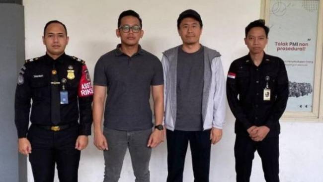 Liu Xiaodong (jaket abu-abu) WNA asal China saat diamankan petugas Kantor Imigrasi Entikong, Kabupaten Sanggau di jalur perbatasan Indonesia-Malaysia. (Foto: Istimewa)