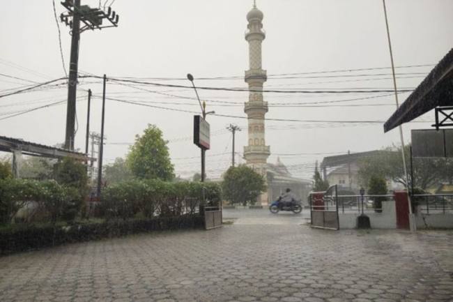 Foto Ilustrasi: Warga melintasi jalan protokol saat hujan mengguyur Kota Palangka Raya, Senin (2/2/2026). (Dok Antara Foto)