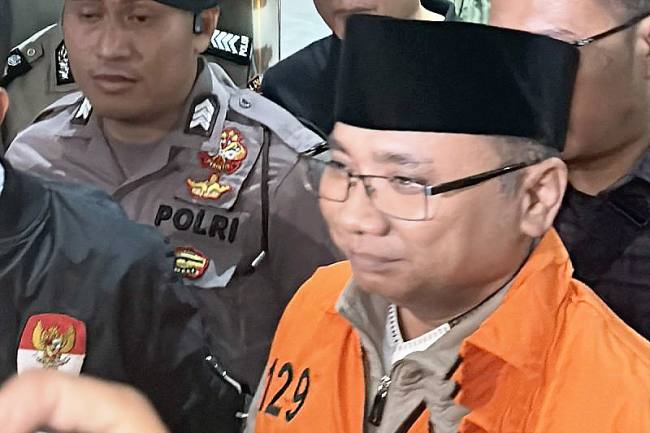 Mantan Menteri Agama sekaligus tersangka kasus kuota haji Yaqut Cholil Qoumas memakai rompi oranye dan berjalan menuju mobil tahanan di Gedung Merah Putih KPK, Jakarta, Kamis (12/3/2026). (Antara/Rio Feisal)