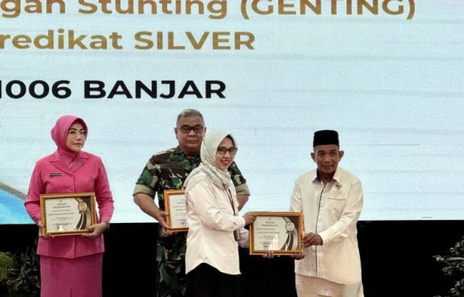 Kepala Perwakilan BKKBN Kalsel Farah Adibah (kedua kanan) menyerahkan penghargaan kepada lembaga yang berperan mencegah stunting pada kegiatan Rapat Koordinasi Daerah Bangga Kencana 2026 di Gedung Mahligai Pancasila, Banjarmasin, Kalimantan Selatan, Kamis (5/3/2026). (Antara/Tumpal A Aritonang)