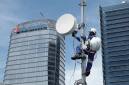 Foto Ilustrasi - Seorang teknisi sedang memasang BTS di menara. (XL Axiata)