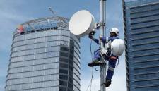 Foto Ilustrasi - Seorang teknisi sedang memasang BTS di menara. (XL Axiata)