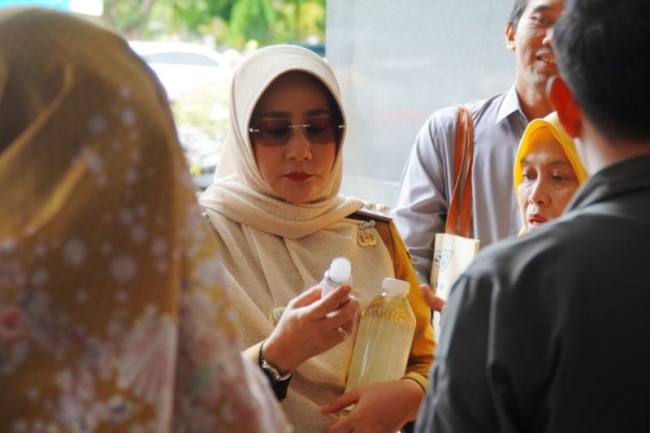 Bupati Berau Sri Juniarsih Mas memperhatikan minyak goreng dari kelapa dalam yang diproduksi oleh pelaku UMKM Kampung Giring-Giring, Kabupaten Berau, Kalimantan Timur. (Dok Prokopim Berau)