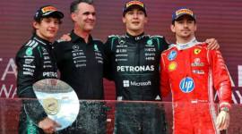 George Russell Pembalap Mercedes merayakan kemenangannya di podium setelah memenangkan Grand Prix Australia bersama Andrea Kimi Antonelli dari Mercedes yang berada di posisi kedua dan Charles Leclerc dari Ferrari yang berada di posisi ketiga, serta manajer unit daya Mercedes F1, Hywel Thomas, Minggu (8/3/2026). (REUTERS/Mark Peterson)