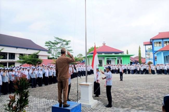 Kepala SMPN 1 Muara Teweh Maslan memimpin apel Senin usai libur hari Raya Idulfitri 1447 Hijriah di halaman SMPN 1 Muara Teweh, Senin (30/3/2026). (Dok SMPN 1 Muara Teweh)