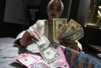 Foto Ilustrasi - Petugas menunjukkan pecahan mata uang dolar Amerika Serikat dan mata uang Rupiah di Kantor Cabang BNI Pasar Baru, Jakarta, Selasa (10/3/2026). (Antara/M Adimaja)