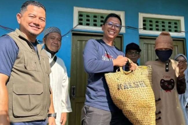 Plt Kadinsos Banjarmasin Jefrie Faransyah dan Sekdakot Banjarmasin Ichrom Muftezar saat menyerahkan bantuan sosial kepada warga, beberapa waktu lalu. (Foto: Antara/Sukarli)