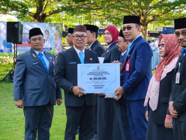 Sekda Kalsel didampingi Kepala Disdikbud Kalsel menyerahkan secara simbolis bantuan untuk program paket kepada kabupaten kota