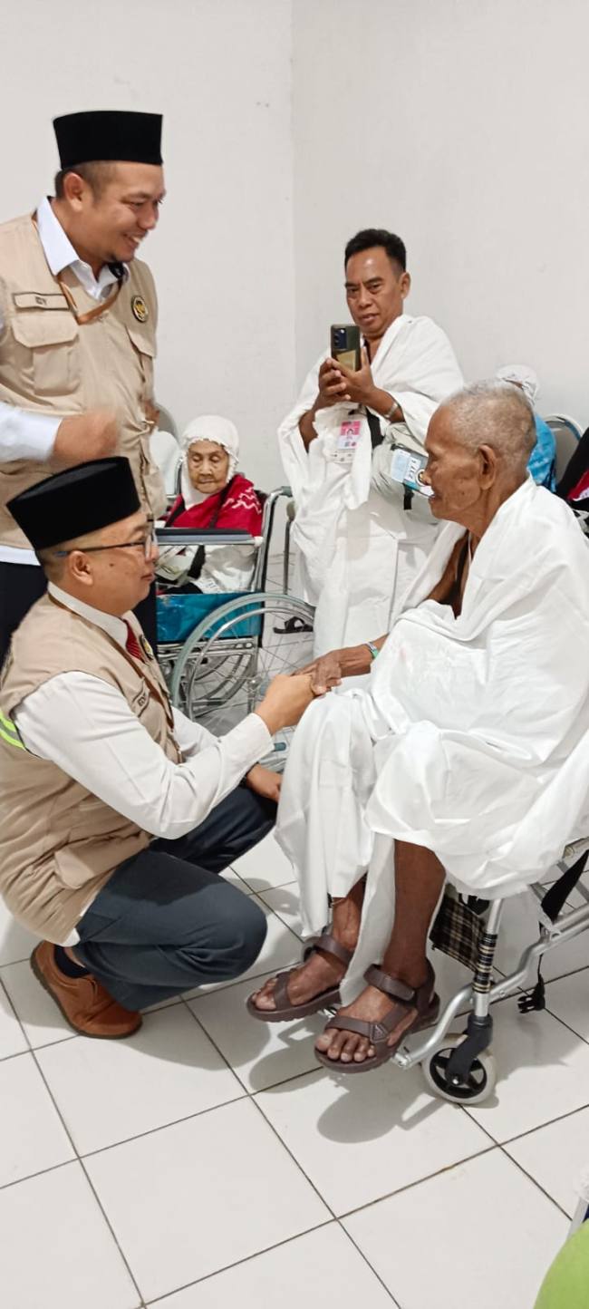 Calon haji tertua Kalsel berusia 102 tahun Mbah Kasrun (duduk kiri) bersama jemaah lainnya dari Kloter 17 Ebarkasi Banjarmasin saat bersiap keberangkatan ke Tanah Suci Makkah, Arab Saudi di asrama haji di Kota Banjarbaru, Senin (18/5/2026). (Foto: Kemenhaj Kalsel)