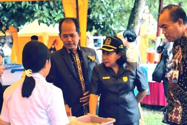 Kepala SMAN 1 Sepang Suyono (kiri), anggota DPRD Gumas Rusmila (bertopi), dan lainnya meninjau stan pameran hasil karya peserta didik di Kelurahan Sepang Simin, Kecamatan Sepang, Kabupaten Gumas. (Foto: Dok SMAN 1 Sepang)
