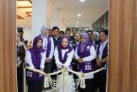 Hj. Fathul Jannah memotong pita tanda diresmikannya Sekre Posyandu Wasaka