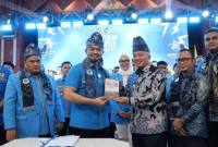 Gubernur Muhidin menerima kenang-kenangan buku dari Ketum KNPI usai pelatikan pengurus Kalsel. Foto : Istimewa