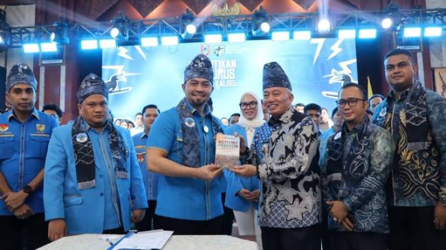 Gubernur Muhidin menerima kenang-kenangan buku dari Ketum KNPI usai pelatikan pengurus Kalsel. Foto : Istimewa
