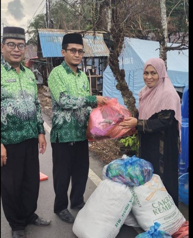 Ketua Perkumpulan Guru Madrasah Indonesia (PGMI) Balangan, Edy Junaidi, didampingi Sekretaris Tajudin Noor dan Bendahara Eliyana, serahkan  paket sembako dan pakaian layak. (SuarIndonesia/Adv)
