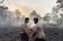 Dua anggota Polres Kubu Raya berjibakumemadamkan kebakaran lahan gambut di Kecamatan Sungai Raya (Foto: Antara/Rendra Oxtora)