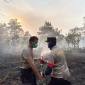 Dua anggota Polres Kubu Raya berjibakumemadamkan kebakaran lahan gambut di Kecamatan Sungai Raya (Foto: Antara/Rendra Oxtora)