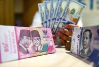 Petugas menunjukan uang pecahan dolar AS dan rupiah di Bank BSI, Jakarta, Selasa (3/9/2024). (Foto: Dok Antara)