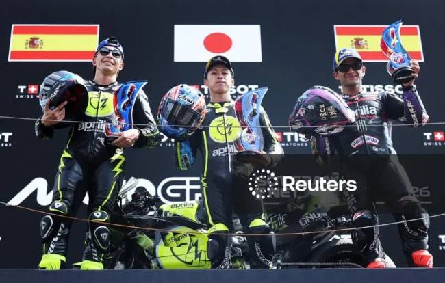Ai Ogura dari Tim Trackhouse MotoGP merayakan kemenangannya di podium dengan trofi setelah memenangkan balapan MotoGP Belanda 2026 bersama rekan satu timnya Raul Fernandez yang berada di posisi kedua dan Jorge Martin dari Aprilia Racing yang berada di posisi ketiga. (Foto: REUTERS/Omar Havana)