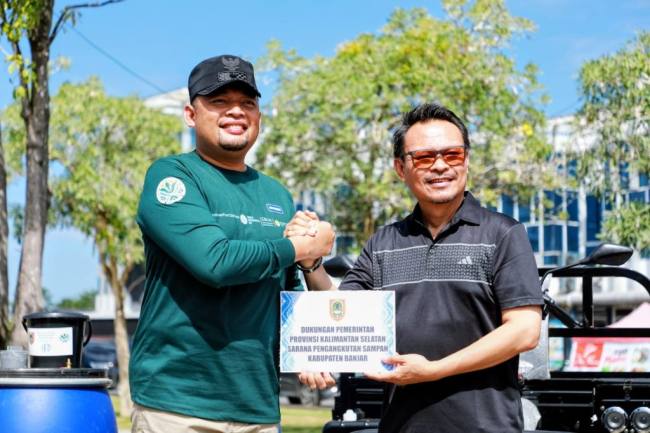 Plh Sekda Kalsel (kanan) menyerahkan secara simbolis bantuan fasilitas pengelolaan sampah di Kota Banjarmasin. Foto : Istimewa