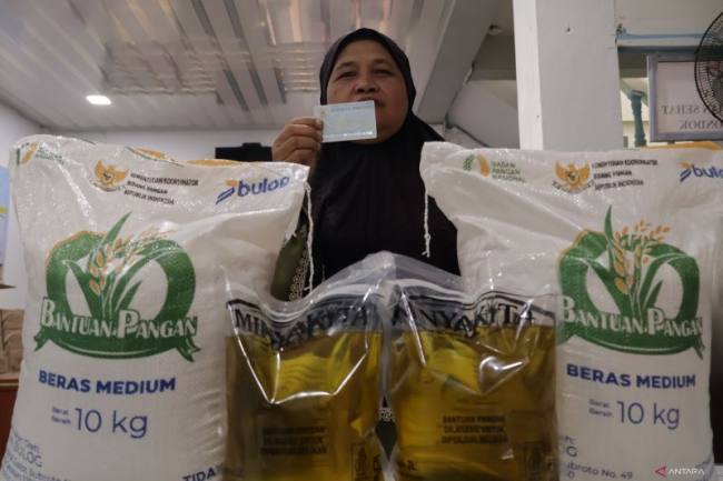 Warga mengambil bantuan sosial berupa beras dan minyak goreng yang disalurkan Pemerintah Kota Padang, Sumatera Barat. (Foto: Antara/M Zulfikar)